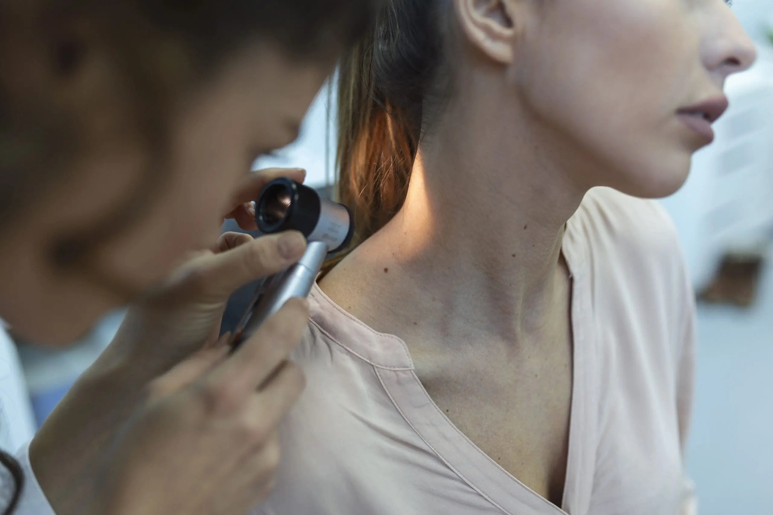 dermatologist latex gloves holding dermatoscope while examining attractive patient with skin disease female dermatologist examining patient with dermascope looking signs skin cancer scaled